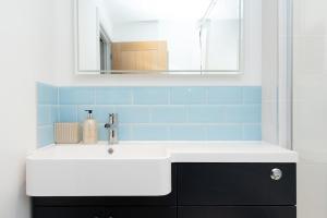 a bathroom with a white sink and blue tiles at Regent Street Residence Lutterworth in Lutterworth +21 photos