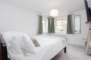 a white bed in a room with a window at Regent Street Residence Lutterworth in Lutterworth
