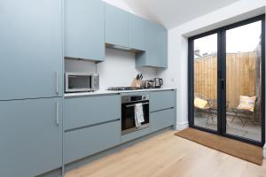 a kitchen with blue cabinets and a stove at Regent Street Residence Lutterworth in Lutterworth
