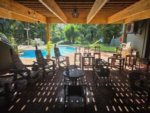 a patio with tables and chairs and a pool at Nguni Gaste Huis in Mooinooi