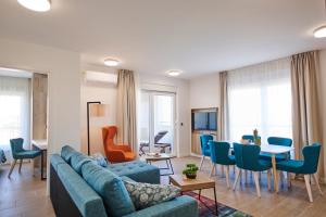 a living room with a couch and a table and chairs at Arancini Residence in Vodice