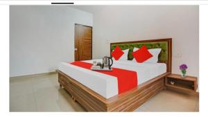 a bedroom with a large bed with red and green pillows at Hotel R Himalayan in Mohali