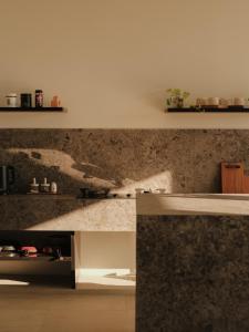 a kitchen with a marble counter top and a shelf at Tris Villas ocean view in Kuta Lombok +32 photos