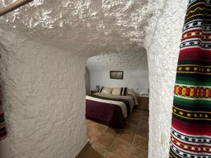 a bedroom with a bed in a white room at Las cuevas de María in Bácor +35 photos