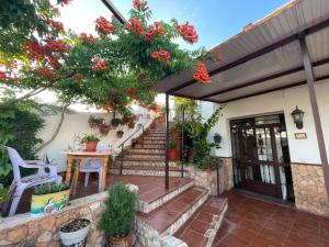 a house with a staircase with red flowers on it at Las cuevas de María in Bácor