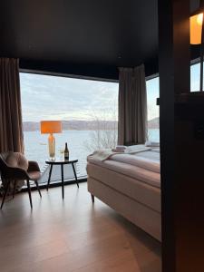 a bedroom with a large window with a bed and a table at Aurora Sea Lodges in Karpbukt