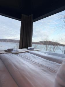 a bed in a room with a large window at Aurora Sea Lodges in Karpbukt