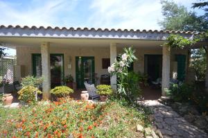 a house with a patio and flowers in the yard at La Lomita in Santa Marinella