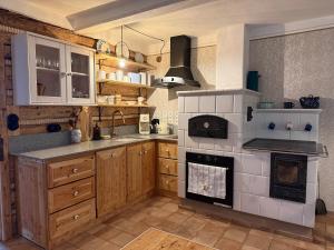a kitchen with wooden cabinets and a stove top oven at Dom Na Biegunach in Cięcina