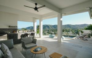 a living room with a ceiling fan and a table at Tris Villas ocean view in Kuta Lombok