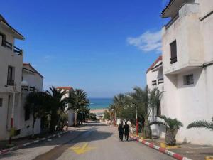 a couple of people walking down a street at Résidence EPLF SAKET BÉJAÏA in Bejaïa