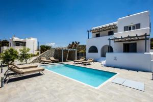 a villa with a swimming pool in front of a house at Naxos Infinity Villa and Suites in Naxos Chora