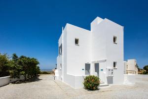 a white building with a blue sky in the background at Naxos Infinity Villa and Suites in Naxos Chora