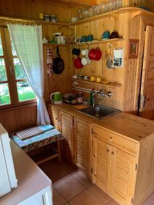 a kitchen with wooden cabinets and a sink and a window at Ivói Faház in Izvoare