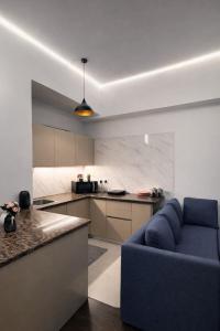 a living room with a blue couch and a kitchen at Glory Stays in Noida