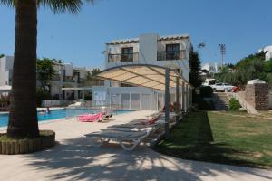 a resort with a pool and some lounge chairs at Gumbet Cove Hotel in Gümbet