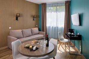 a living room with a couch and a table at Zenitude Swiss Apparthotels in Ferney-Voltaire
