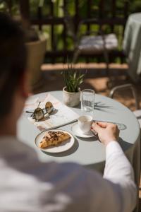 a person sitting at a table with a plate of pizza at Hotel Öhlerhof in Lagundo