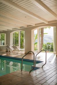a room with a pool with chairs and windows at Hotel Öhlerhof in Lagundo