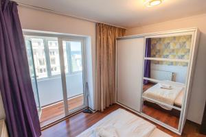 a bedroom with a bed and a large window at Dor de Mare - Piata Ovidiu Constanta in Constanţa