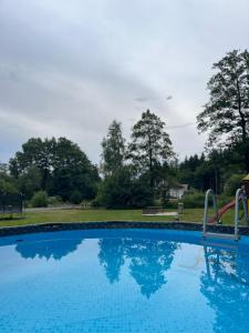 a swimming pool with a slide in a park at Apartmány Ve Mlejně in Čachrov