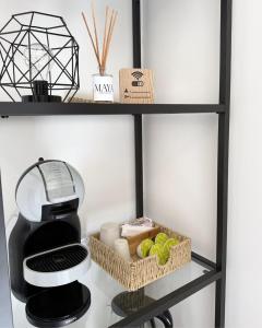 a black shelf with a coffee maker and food at Maya Apartments in La Maddalena