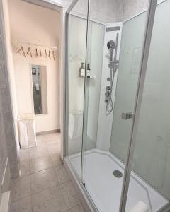 a shower with a glass door in a bathroom at Maya Apartments in La Maddalena