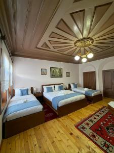 a bedroom with two beds and a ceiling at Xhulio Guesthouse Berat in Berat