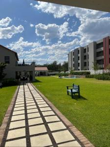 a park with a bench in front of a building at Royalty Suites in Chartwell Sandton in Chartwell