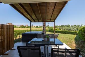 a patio with a table and chairs under a roof at Afitos Luxury Villas in Afitos