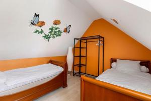 two beds in a room with butterflies on the wall at Gîte La Loge in Saint-Aignan +16 photos