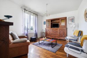 a living room with a couch and a tv at Maison de vacances La Couade in Troche