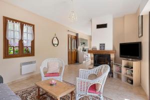 a living room with chairs and a table and a tv at Gîte La Loge in Saint-Aignan