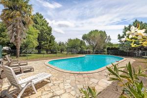 a swimming pool with two lounge chairs next to it at Gîte La Loge in Saint-Aignan