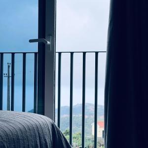 a bedroom with a view of the mountains from a window at Cottagee Grandpa Silva in Santana