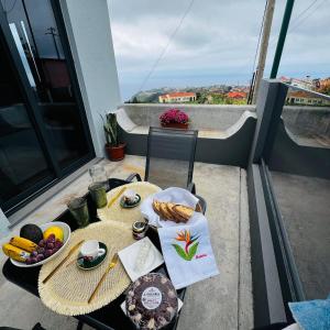 a table with a plate of food on a balcony at Cottagee Grandpa Silva in Santana