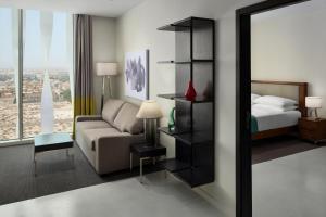 a hotel room with a couch and a bed and a mirror at Staybridge Suites Al Khobar by IHG in Al Khobar