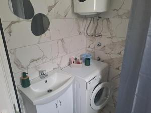 a bathroom with a sink and a washing machine at Perucac Apartman in Perućac