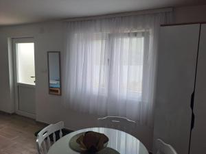 a dining room with a table and a window at Perucac Apartman in Perućac