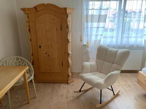 a living room with a chair and a cabinet at Ferienwohnung "Zirbenduft" im Landhotel Seeg in Seeg