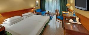 a hotel room with a large bed and a desk at Trance Oakwood Hotel in Pune