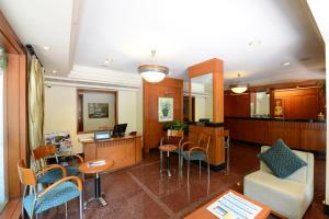 a lobby with a waiting room with a desk and chairs at Trance Oakwood Hotel in Pune