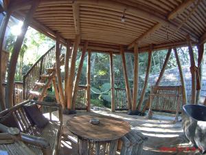 a wooden porch with a table and chairs and a wooden stairs at EcoBamboohouse salacca in Manggis +46 photos