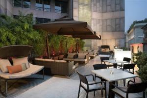 a patio with tables and chairs and a building at Sina The Gray in Milan