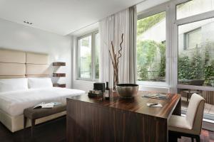 a bedroom with a bed and a desk with a desk at Sina The Gray in Milan
