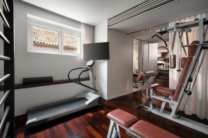 a gym room with a treadmill and a mirror at Sina The Gray in Milan