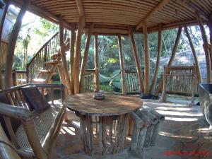 a wooden table and a chair in a pavilion at EcoBamboohouse salacca in Manggis
