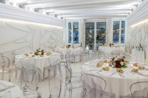 ein Festsaal mit weißen Tischen und Stühlen in der Unterkunft Sina Centurion Palace in Venedig