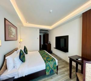 a hotel room with a bed and a flat screen tv at Comfort Hotel Kishore Azamgarh in Āzamgarh