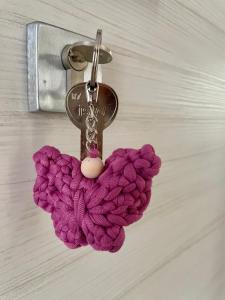 a purple crocheted keychain hanging from a door handle at Villa Giovanna Rooms in Montelabbate